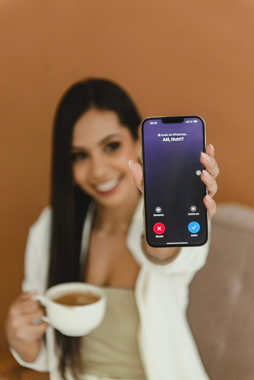 Junia mostrando uma chamada do projeto Alô Nutri no celular