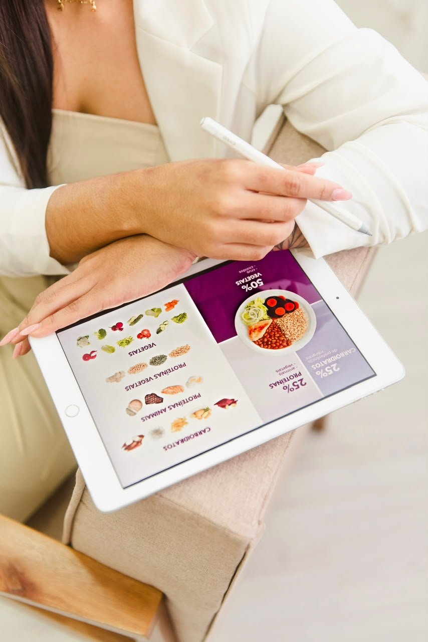 Plano alimentar aberto no tablet durante atendimento nutricional da Junia Souza